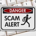 Scam alert warning sign on keyboard background