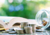 Open book pen coins jar on table