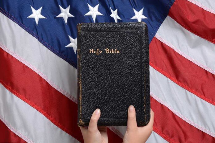 492471811 featured image Bible held in front of American flag.