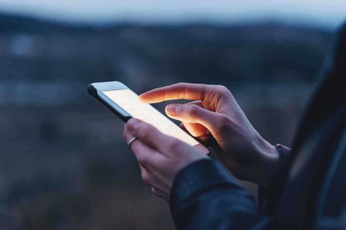 585973055 featured image Person using a smartphone at dusk