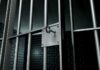 Close up of a locked prison gate with metal bars