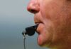 Close up of a sports coach blowing a whistle
