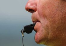Close up of a sports coach blowing a whistle