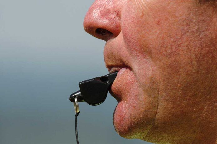 shutterstock_172952840.jpg Close up of a sports coach blowing a whistle