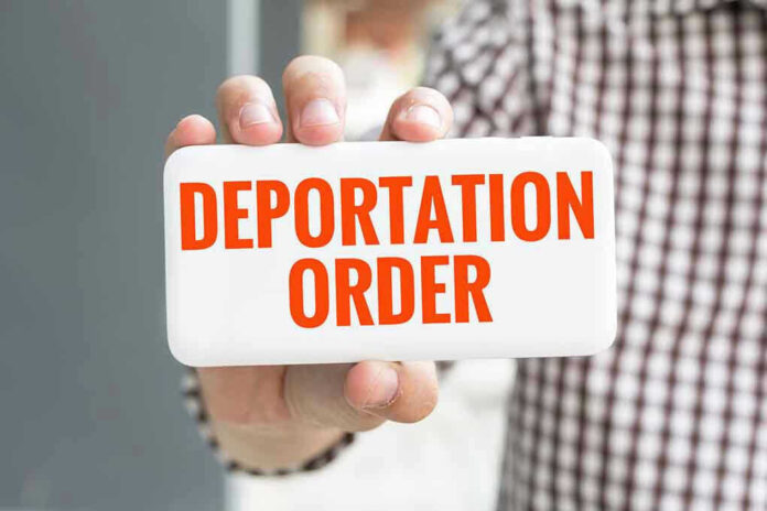 Hand holding sign with "Deportation Order" text.