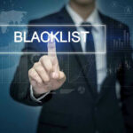 Man pressing virtual blacklist button.