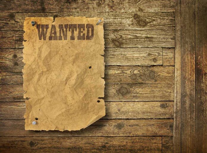 shutterstock_89947687.jpg A vintage wanted poster pinned to a wooden wall
