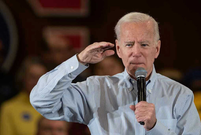 Man holding microphone making a gesture while speaking