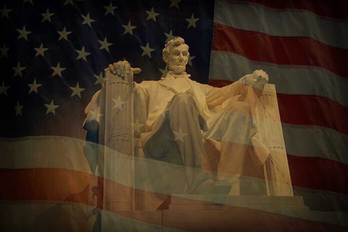 shutterstock_115238551.jpg Statue of Abraham Lincoln seated against a backdrop of the American flag