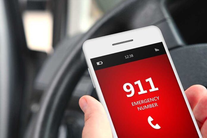 shutterstock_222819127.jpg A smartphone displaying the emergency number 911 while held in a persons hand inside a car