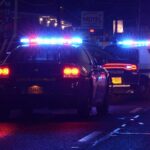 Mayor Orders Police Home Invasion After Public Criticism Police cars with flashing lights at a nighttime scene near a motel