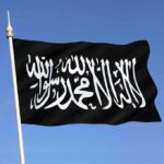 Muslim Flags Raised Across U.S – What’s Really Happening? Black flag featuring Arabic script against a blue sky