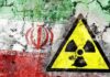 A cracked wall featuring the Iranian flag and a nuclear warning symbol