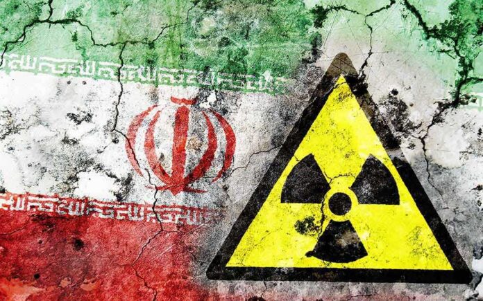 shutterstock_165080393.jpg A cracked wall featuring the Iranian flag and a nuclear warning symbol
