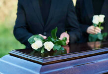 Congressman Dies Aged 86, Leaves Lasting Legacy People placing white roses on a casket.