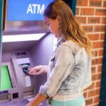 Young woman using an ATM in an urban environment