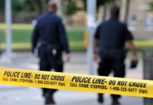 Footage Shows PSYCHO Throwing Knives at Cops Before Shooting! Police officers walking past caution tape at a crime scene