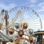 Colorful amusement park scene featuring a ferris wheel and carousel