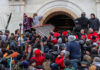 Large crowd storming the entrance of a building.