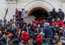 Large crowd storming the entrance of a building.