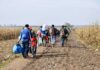 TOP State Jobs Set Aside for Muslim Migrants! Group of people walking along a muddy rural path between fields