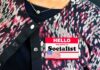 Person wearing patterned cardigan with a name badge on chest