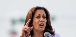 Woman in white shirt speaking into a handheld microphone