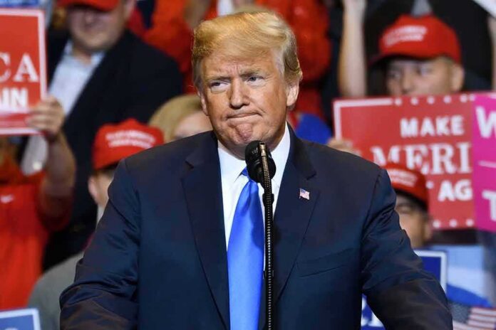 man in suit speaking at a rally podium