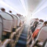 Airplane cabin aisle with blurred passengers and seats