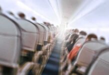 Airplane cabin aisle with blurred passengers and seats