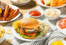 Cheeseburger on a plate with potato salad and corn on the cob