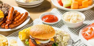 Cheeseburger on a plate with potato salad and corn on the cob