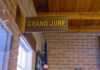 Juror ATTACKED For Being A Republican Grand jury sign in a brick-walled hallway