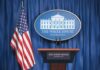 Trump Launches TV Channel Amid Press Revolt White House press briefing podium and US flag