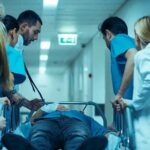 Medical team rushing patient on a gurney through hospital corridor
