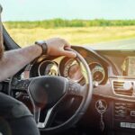 Driver's hands on steering wheel of car interior