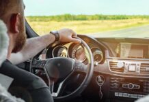 Driver's hands on steering wheel of car interior