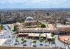 historic mosque with domes and minaret overlooking a busy city square