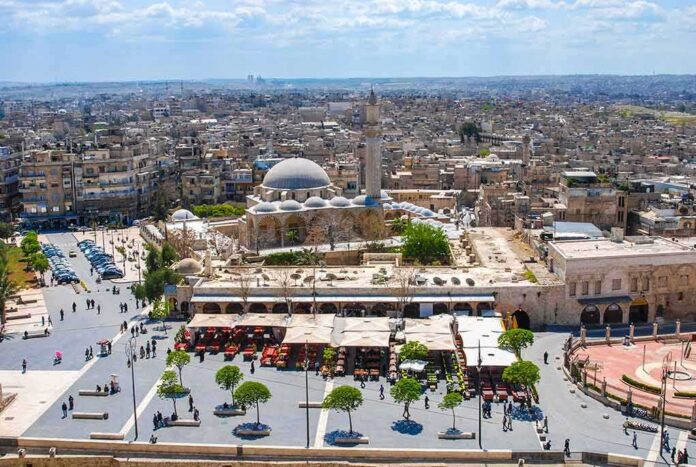 historic mosque with domes and minaret overlooking a busy city square