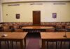 Empty courtroom with wooden tables and gallery seating