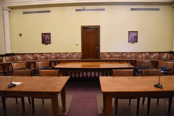 Empty courtroom with wooden tables and gallery seating