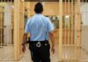 corrections officer walking through prison corridor