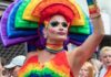 Drag performer in vibrant rainbow costume at a parade