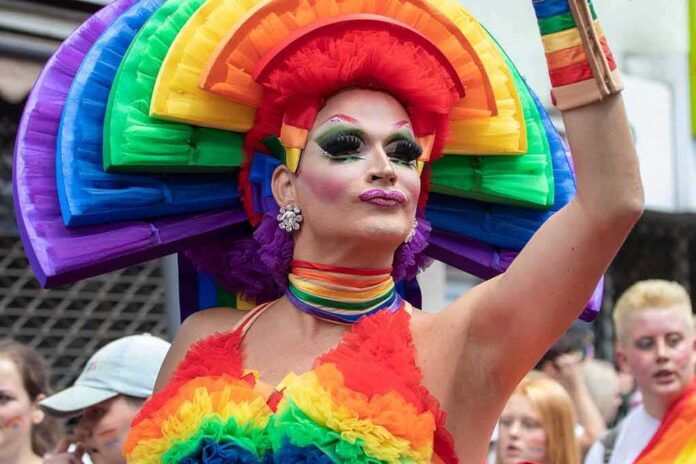 Drag performer in vibrant rainbow costume at a parade