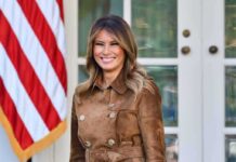 Melania Strikes LUCRATIVE White House Side Hustle woman smiling in a brown suede coat