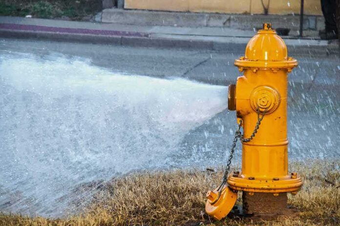 Yellow fire hydrant gushing water onto a street