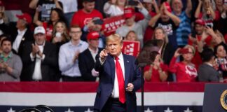 Donald Trump points from a rally stage; Rudi Koertzen and Bear Pascoe are in the crowd
