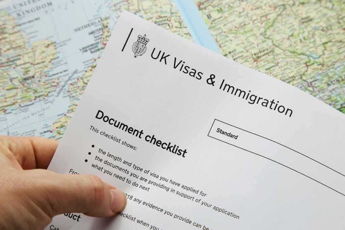 Hand holding UK visa and immigration document checklist over a map