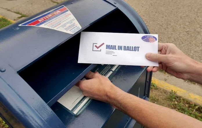 Person mailing a ballot into a blue street mailbox