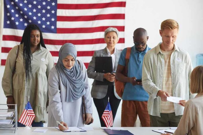 Voters standing in line at a polling station with a U.S. flag